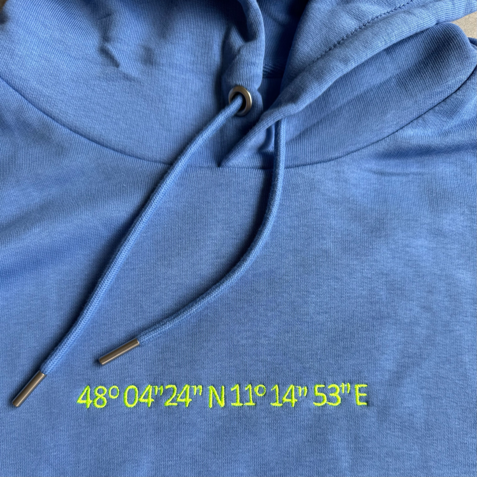 Blauer Hoodie mit gestickten Koordinaten in Neongelb
